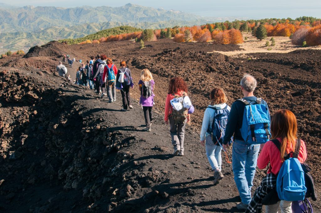 Group of hikers walking on a trail on to the north side of Moun Etna