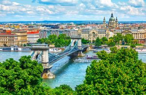 Chain bridge on Danube river in Budapest city, Hungary. Urban landscape panorama with old buildings and domes of opera buildings