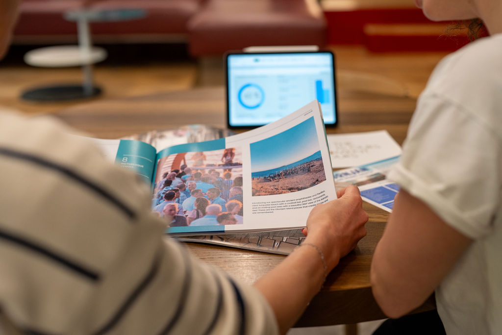 Two people with brochure and tablet selecting an event program.