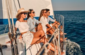 Group of friends relaxing on luxury yacht. Having fun together while sailing in the sea. Traveling and yachting concept.