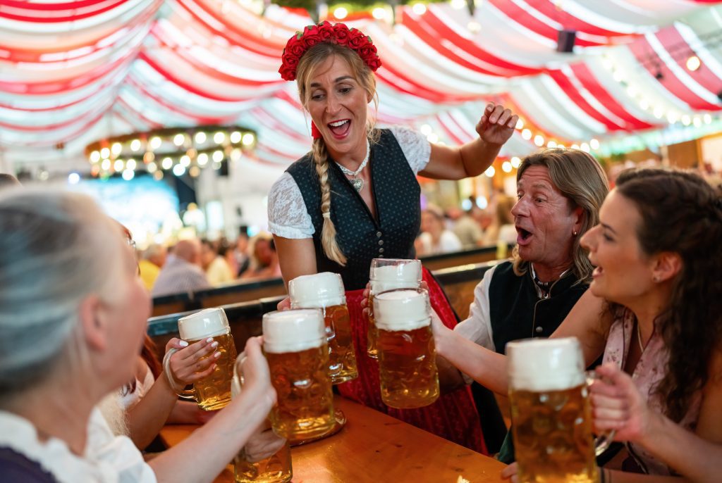 Team at Oktoberfest drinking beer, happy moment.