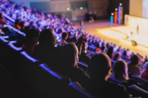Audience Listening to Panel Discussion in Modern Conference Hall.