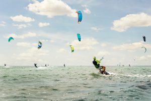 Grosse Gruppe von Kitesurfern im Wasser.