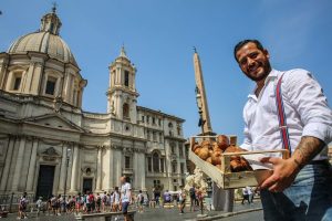 Italian man in rome with a basket of mushrooms for sale.