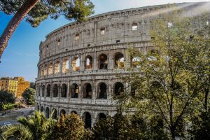 Colosseum in Rome from the outside with trees in front.