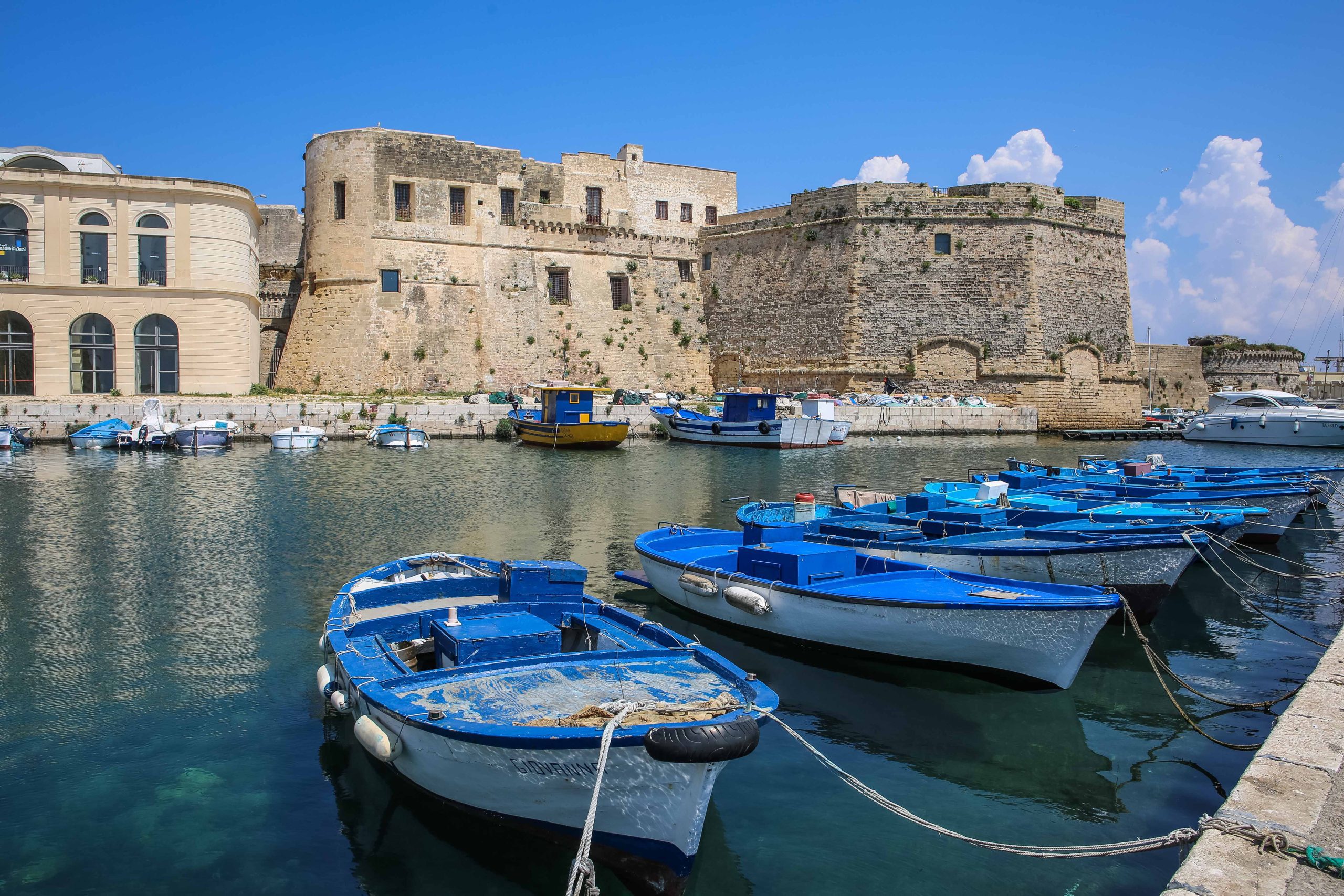 Small, blue boats on the water in small harbor.