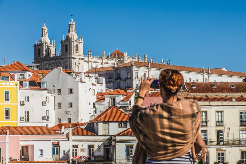 Woman in Lisbon taking a picture of the city, tourist.