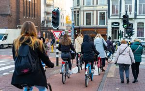 Gruppe von Menschen mit Fahrrädern auf den Strassen von Amsterdam.