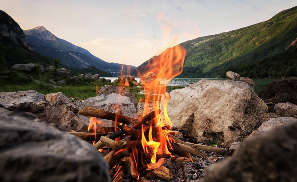 Campfire in the mountains by a lake.