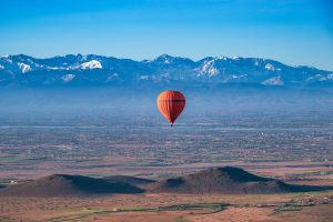 Red Hot Air Balloon flying over the desert near Marrakech.