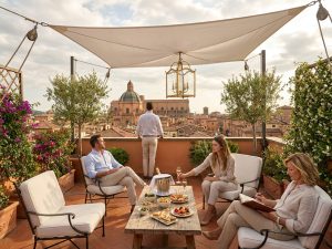 Team enjoying breakfast on a shaded rooftop terrace overlooking the Bologna countryside