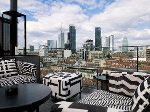 Outdoor terrace bar with seating at a centrally located Milan hotel