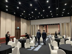 Conference room set with round banquet tables and white chair covers for a corporate event