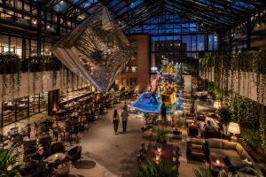 Covered restaurant terrace in Berlin with wooden tables, hanging greenery and warm evening lighting