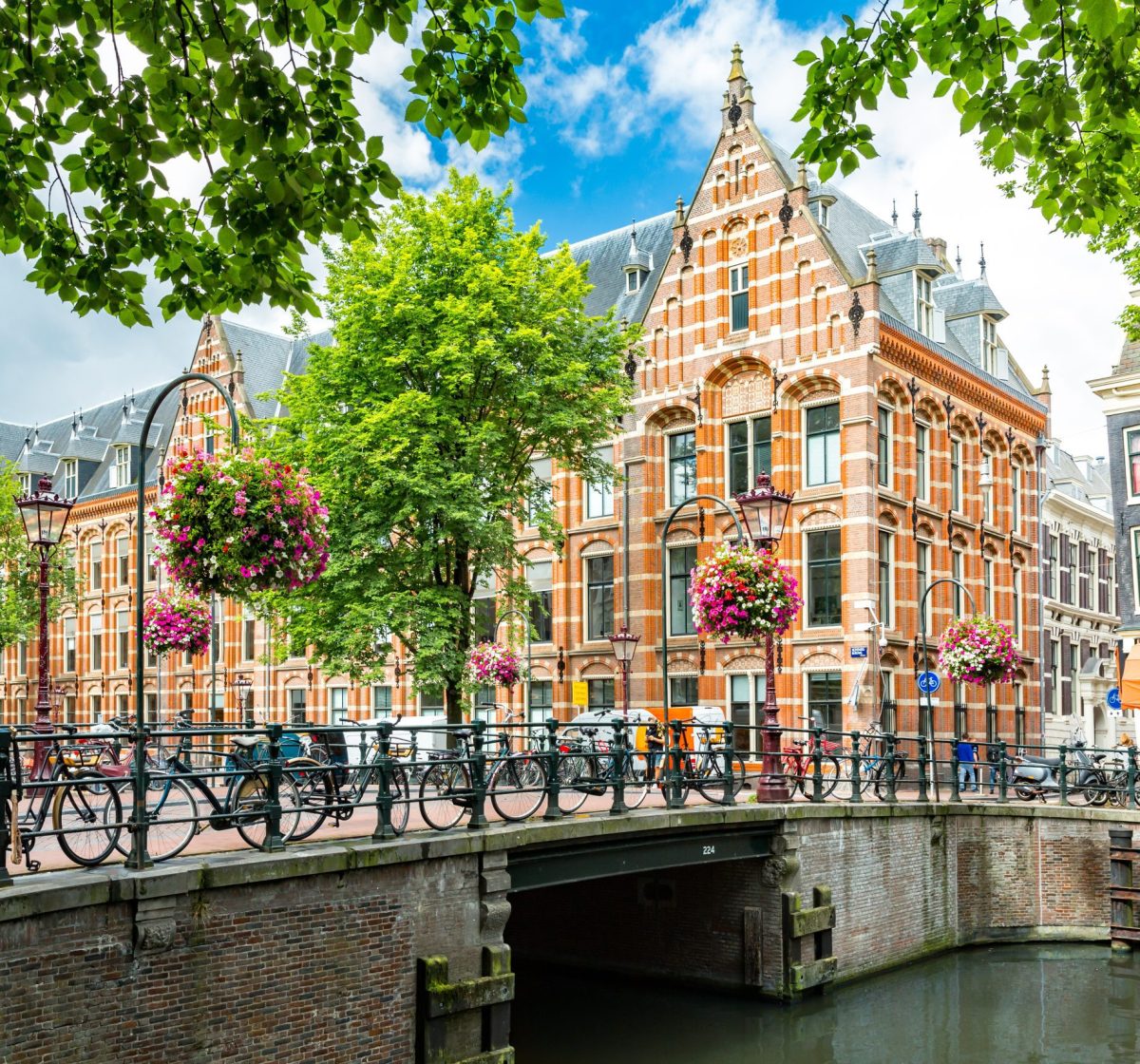 Typical canal side cityscape of Amsterdam, opposite from the 17th century HQ of the Dutch East India Company, now used by the University of Amsterdam